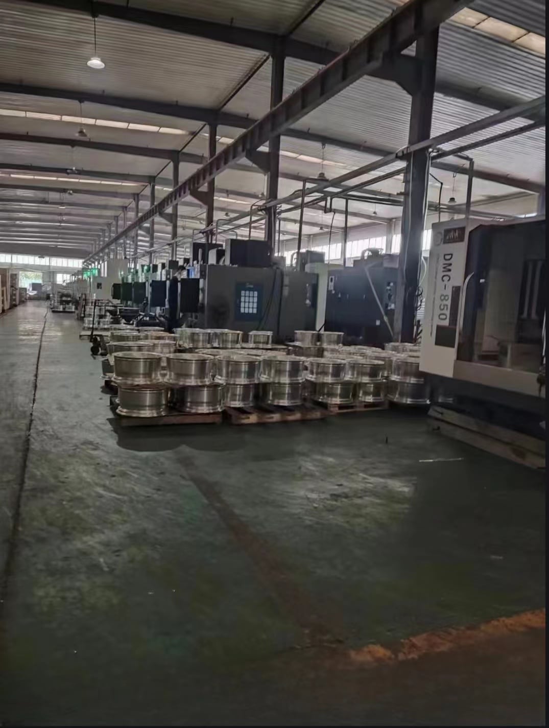 Wheel manufacturing workshop with organized racks and machining stations