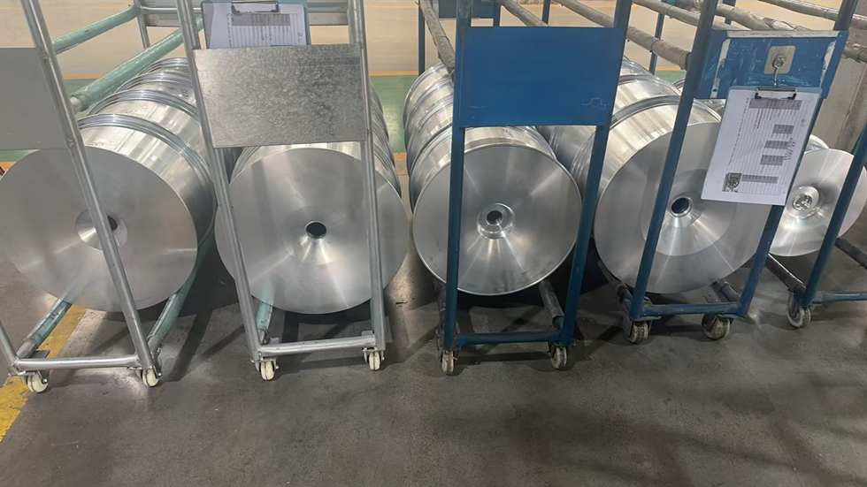 Prepared alloy wheels arranged on racks before coating
