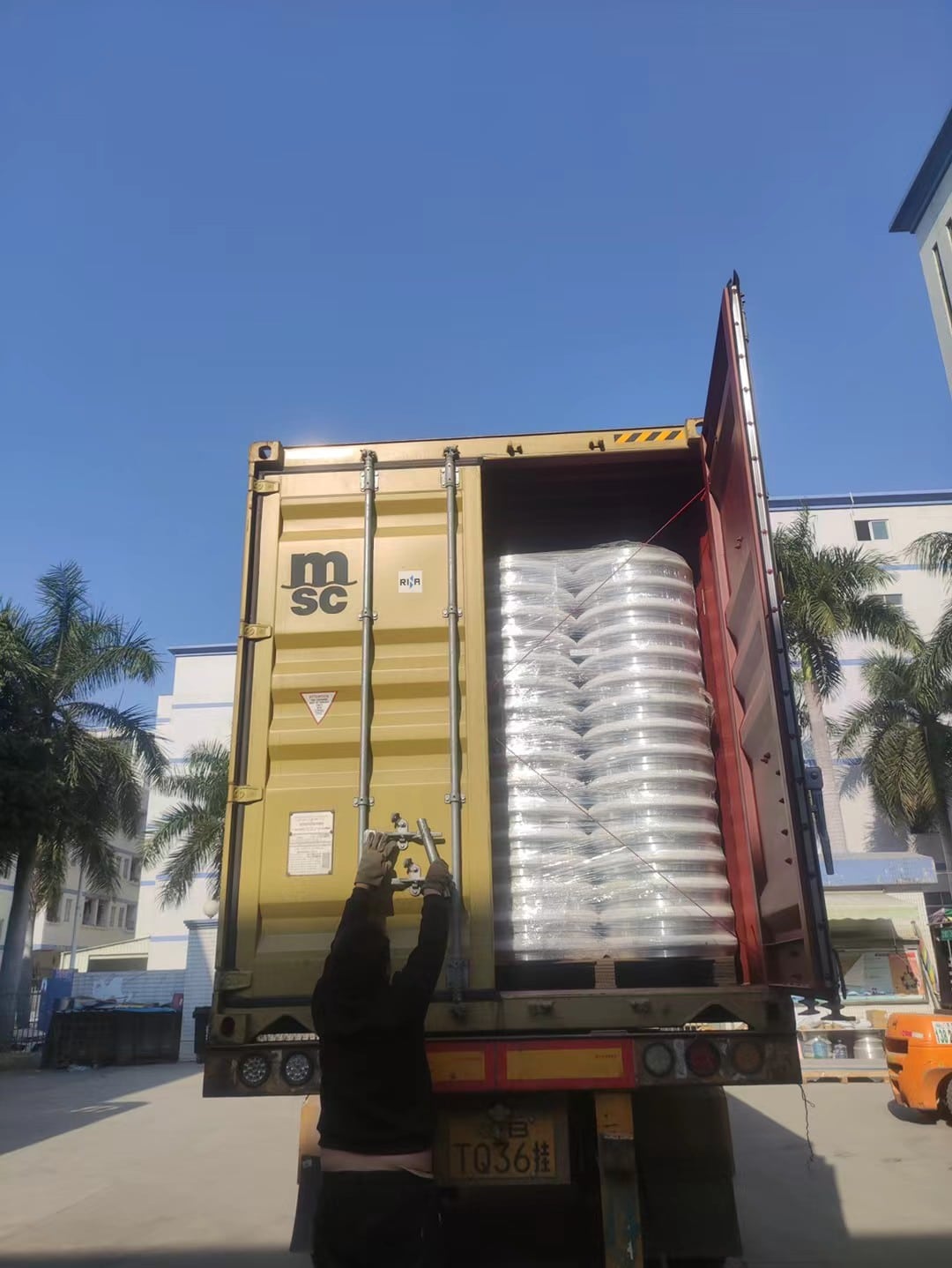 Closed export container being checked after alloy wheel cartons are loaded