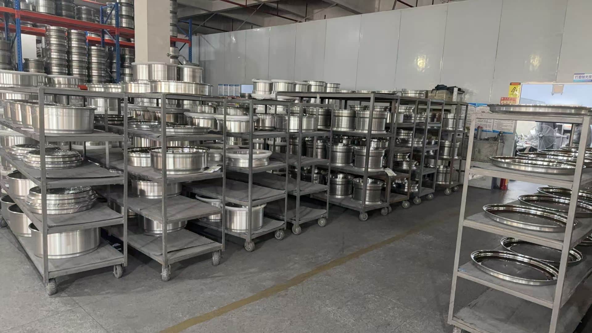Machined alloy wheel rims arranged on racks by specification